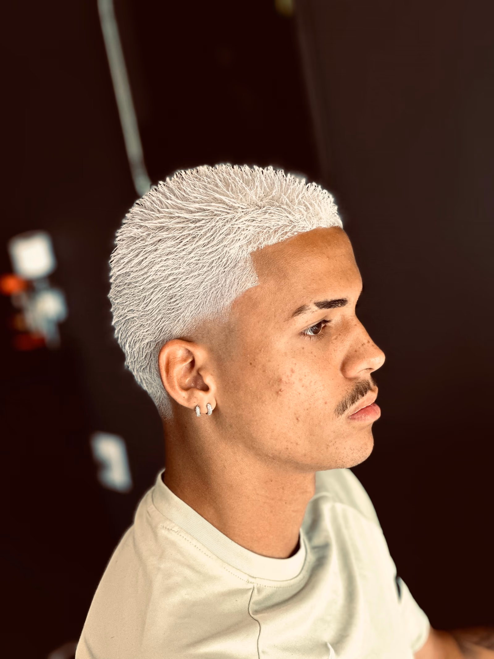 Cabelo platinado em corte quadrado alto, com degradê e contorno na régua